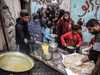 غزيون يصطفون للحصول على وجبة طعام من جمعية خيرية