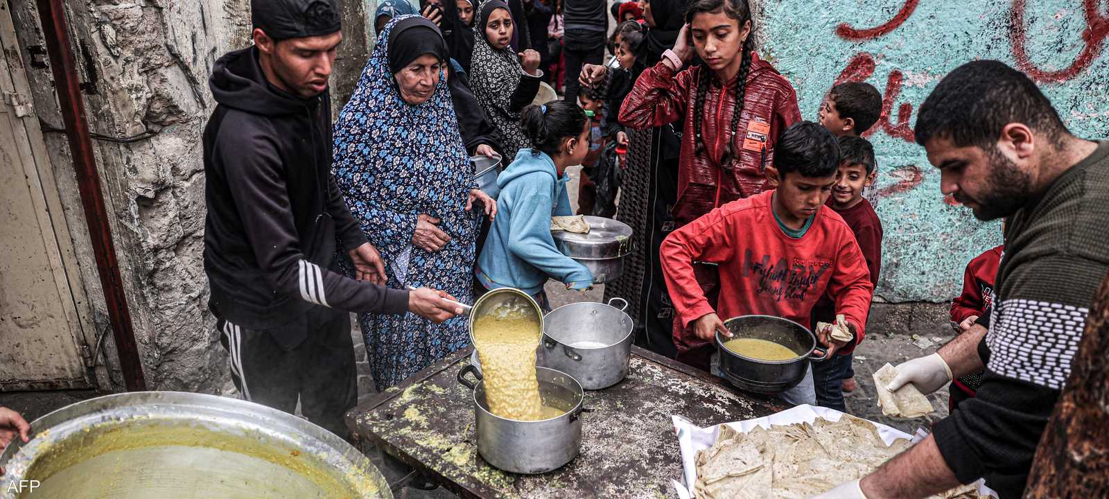 غزيون يصطفون للحصول على وجبة طعام من جمعية خيرية