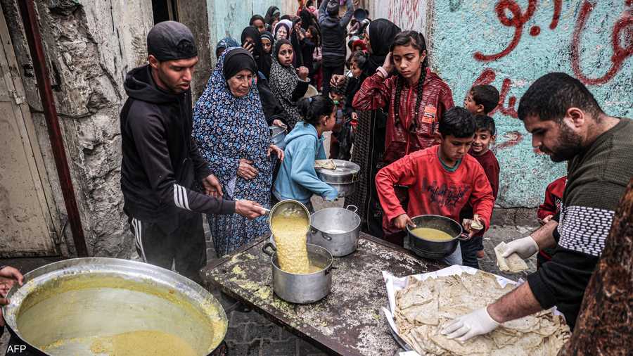 غزيون يصطفون للحصول على وجبة طعام من جمعية خيرية