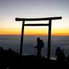سياح يشاهدون شروق الشمس من فوق قمة جبل فوجي