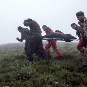 جنود يحملون جثث ضحايا تحطم طائرة رئيسي