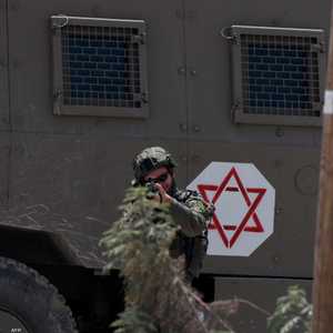 جندي إسرائيلي يصوب سلاحه نحو شبان فلسطينيين بالضفة الغربية