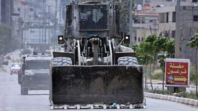 مركبة مدرعة تابعة للقوات الإسرائيلية تسير خلف جرافة في جنين