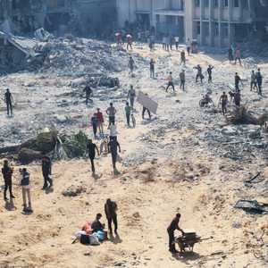 فلسطينيون بمقر الأونروا المدمر في حي الصناعة في مدينة غزة