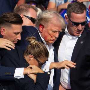 إحدى العميلات في الخدمة السرية وهي تحاول مساعدة ترامب