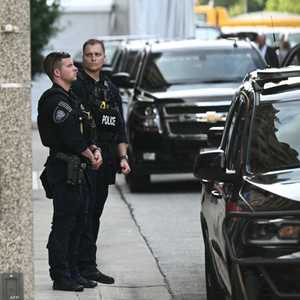 عنصران من الشرطة يقفان أمام موكب ترامب