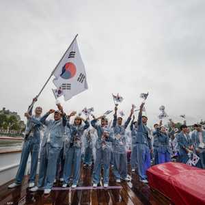 الرياضيون الكوريون الجنوبيون يلوحون بعلم بلادهم على متن قارب