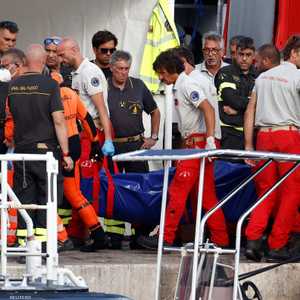 أفراد الإنقاذ ينقلون إحدى الجثث بعد غرق اليخت