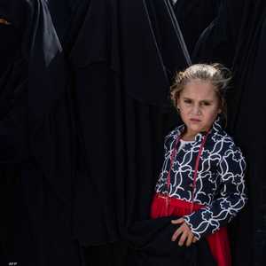 طفلة مع والدتها بمخيم الهول