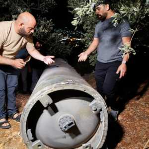 فلسطينيان يفحصان قذيفة أطلقتها إيران باتجاه إسرائيل