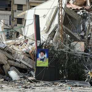 صورة حسن نصر الله على أنقاض مبنى دمر في غارة جوية إسرائيلية