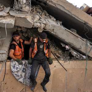 عناصر من طواقم الإنقاذ يخرجون من منزل مدمر في خان يونس