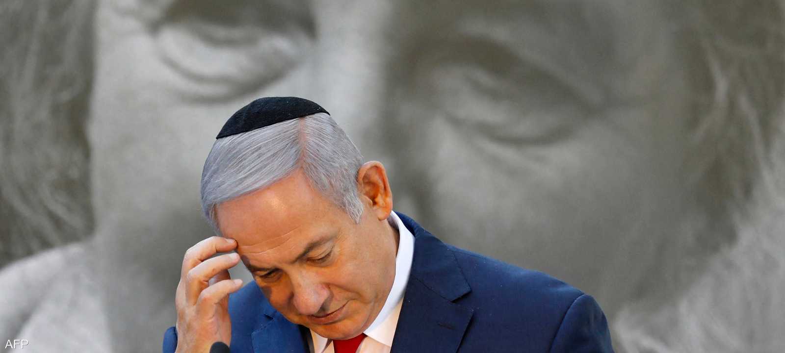 بنيامين نتنياهو ومن خلفه صورة لغولدا مائير