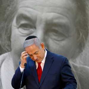 بنيامين نتنياهو ومن خلفه صورة لغولدا مائير