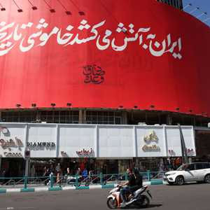 لوحة في طهران تحمل شعار "إيران تشعل النار في ظلام التاريخ"