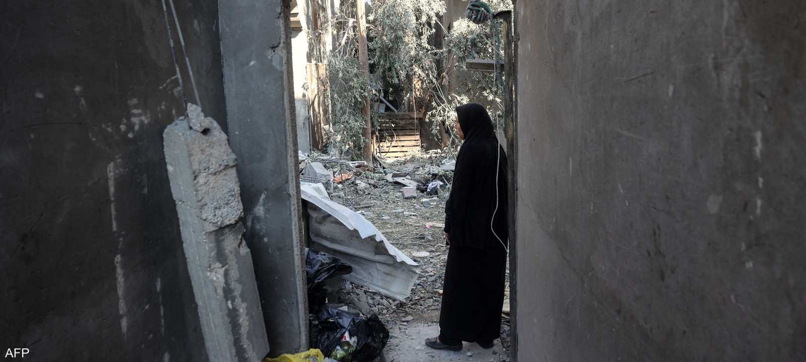 امرأة تتفقد الأضرار التي لحقت بمنزلها بعد غارة إسرائيلية