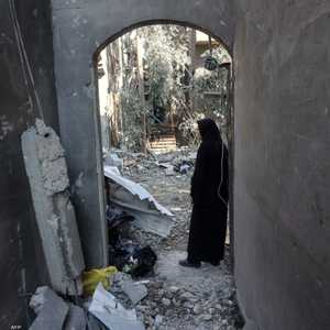 امرأة تتفقد الأضرار التي لحقت بمنزلها بعد غارة إسرائيلية