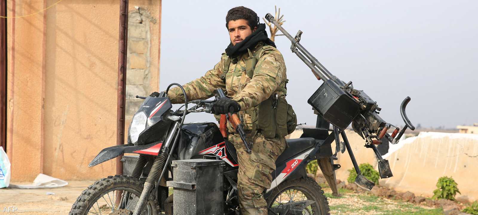 مسلح يركب دراجته النارية في مدينة الرستن السورية