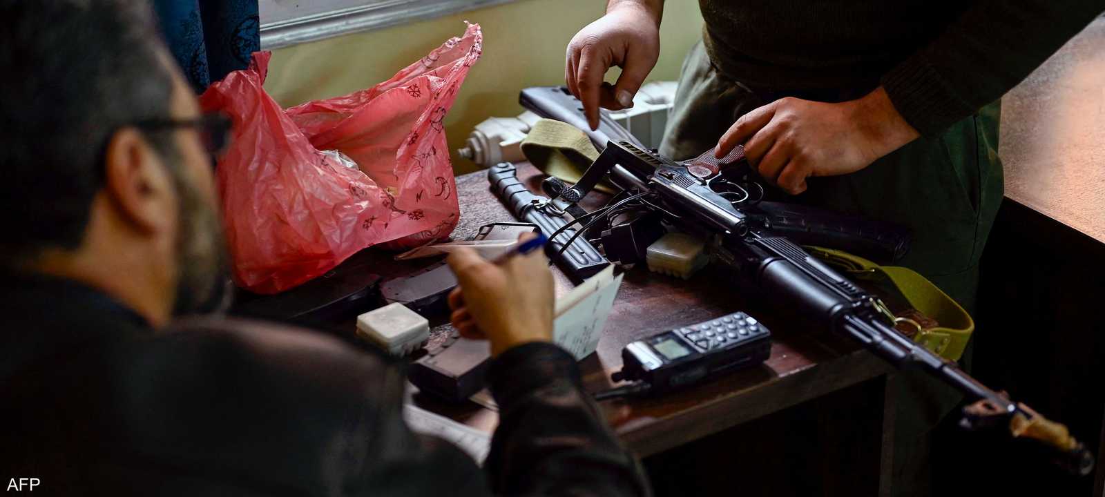 رجل يسلم معداته لعضو من السلطات السورية الجديدة - أرشيفية