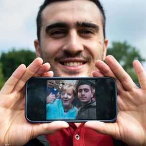 أنس مودماني يعرض صورة التقطها مع أنغيلا ميركل