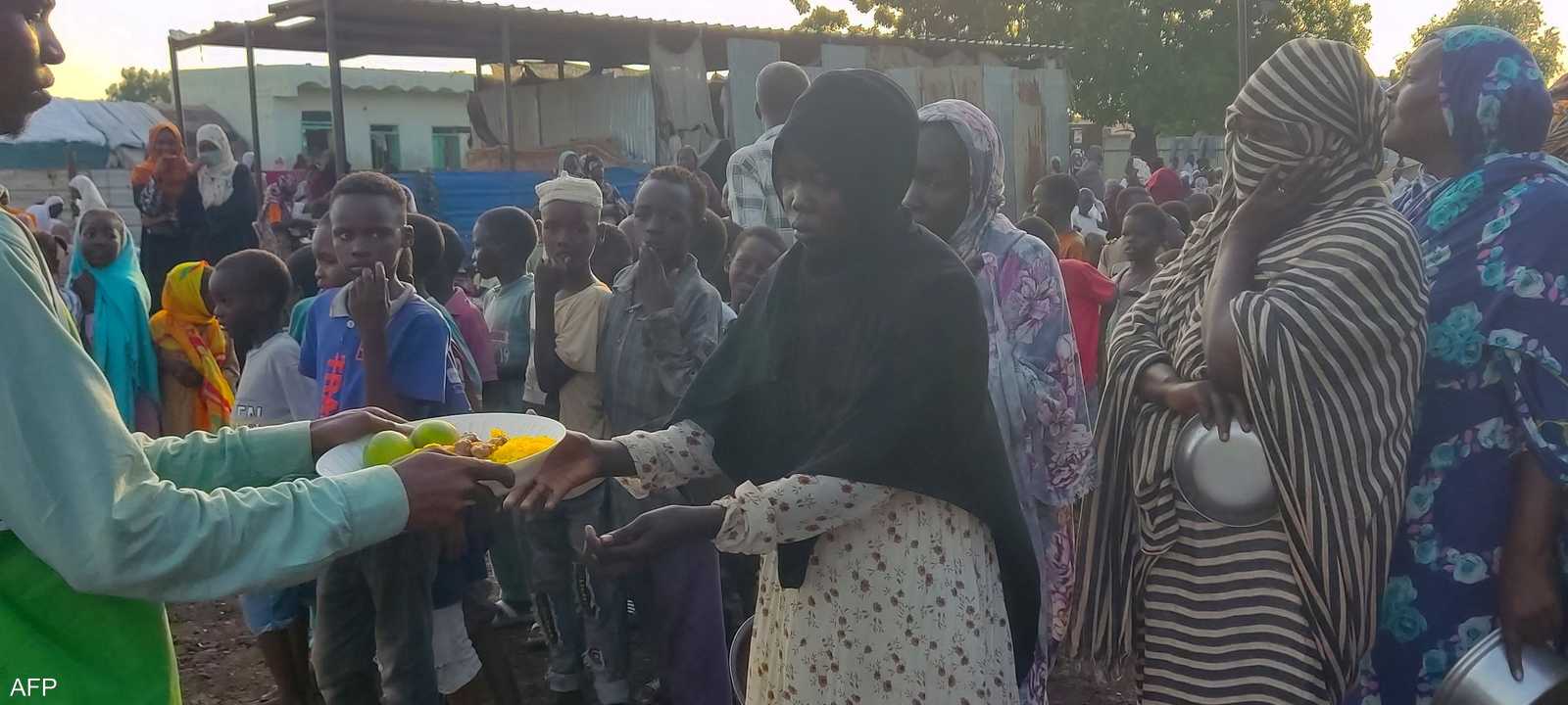 توزيع الطعام على سودانيين في إحدى المخيمات