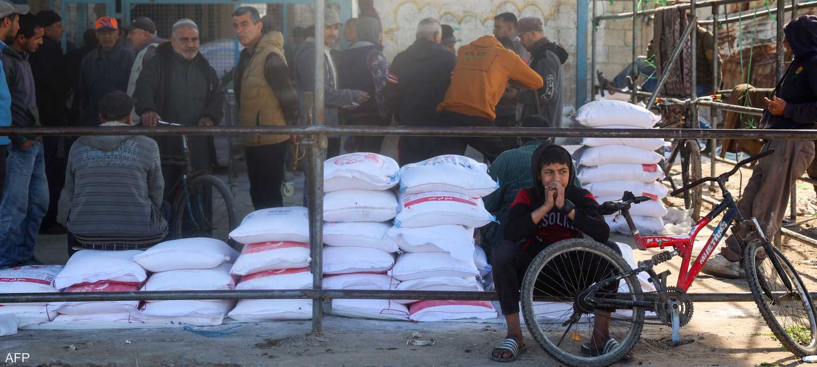 فلسطينيون يصطفون لتلقي مساعدات غذائية