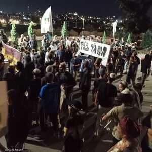 مستوطنون يحملون لافتة "قائد الكتيبة خائن"