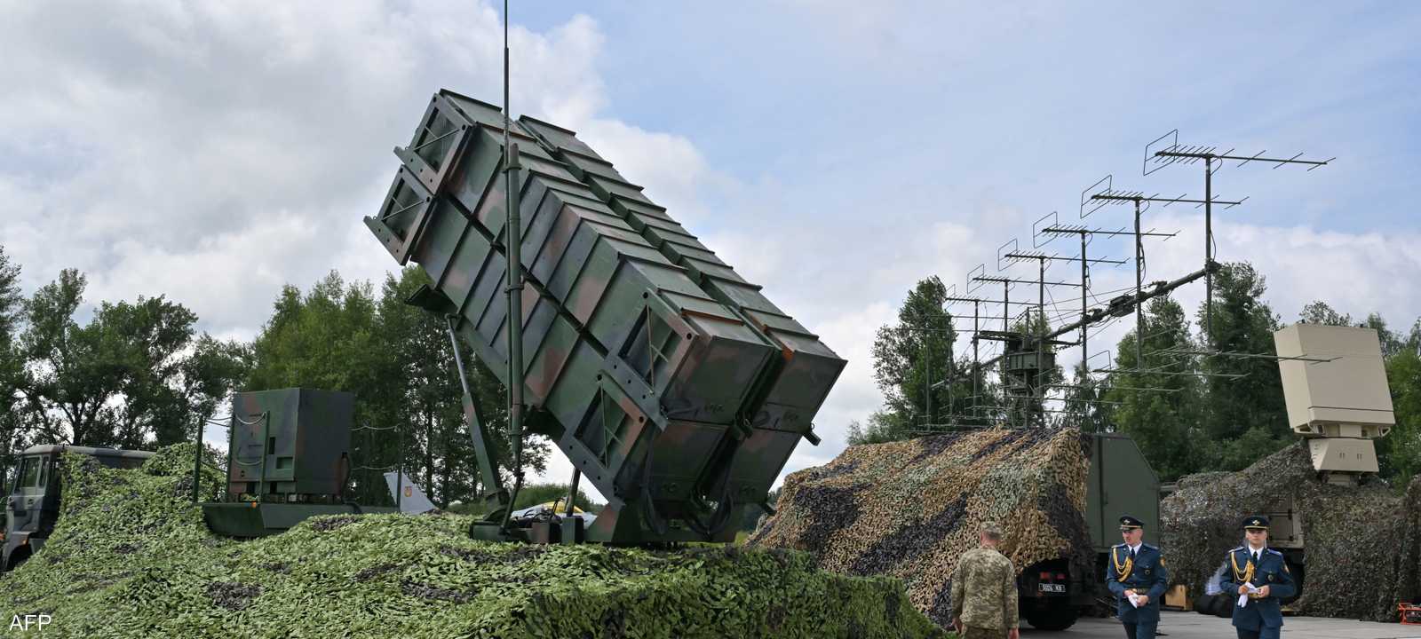 جنود أوكرانيون يمرون أمام نظام دفاع جوي من طراز باتريوت