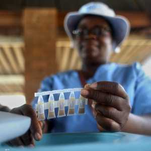 عامل صحي يحمل عينة من لقاحات الكوليرا