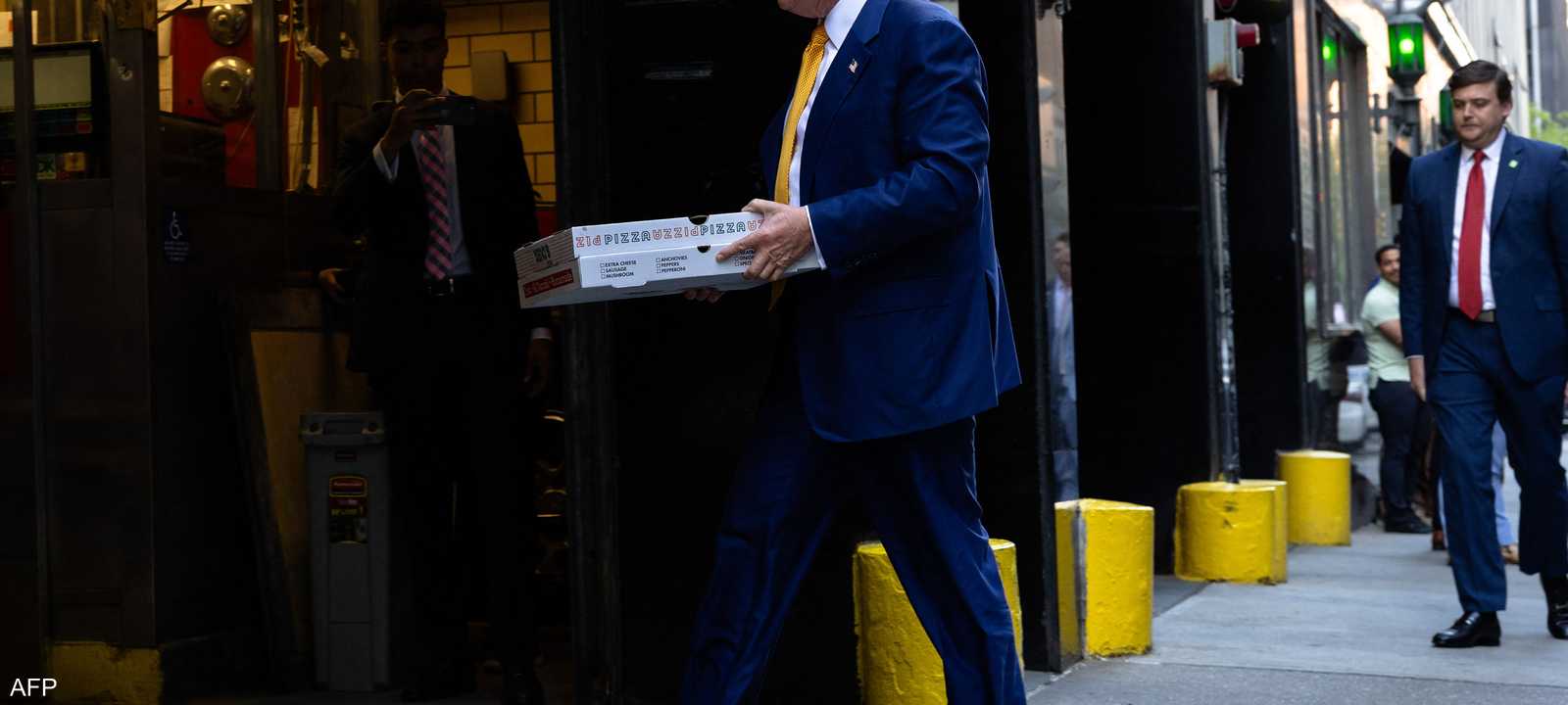 الرئيس ترامب يحمل علبة بيتزا.. أرشيفية