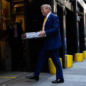 الرئيس ترامب يحمل علبة بيتزا.. أرشيفية