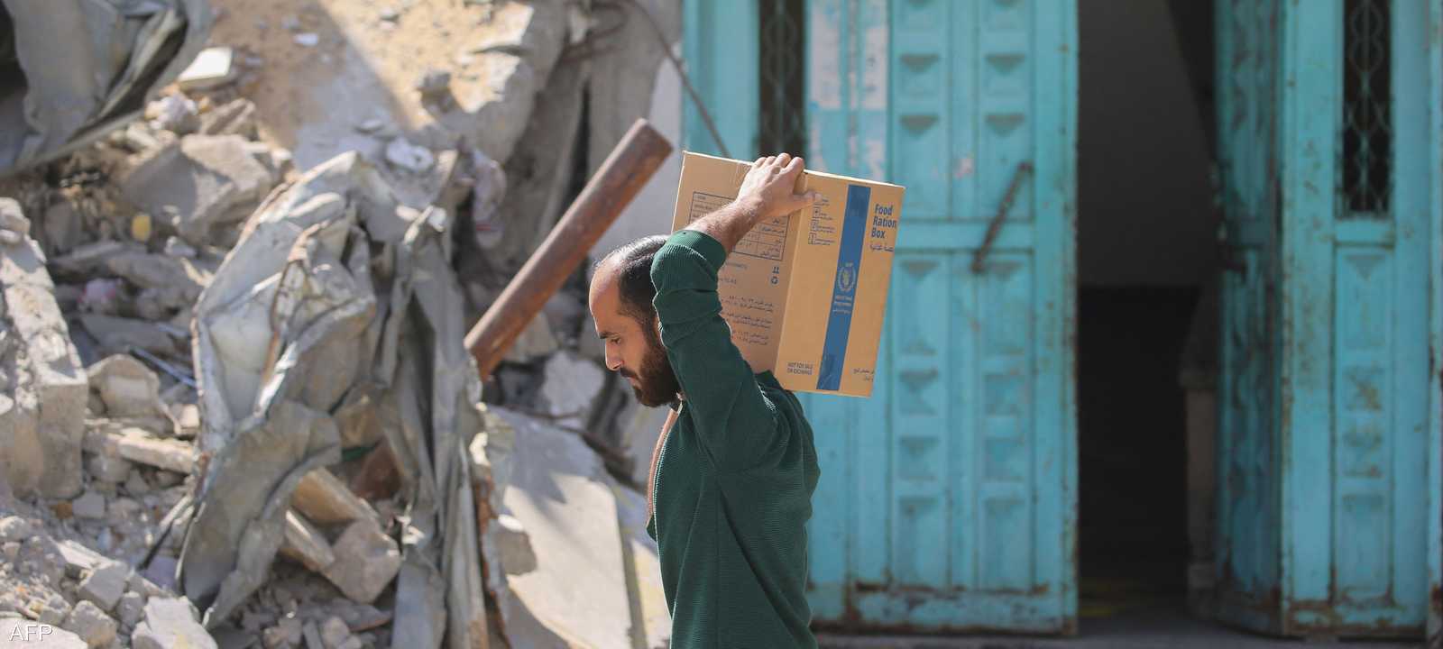 فلسطيني نازح يحمل صندوقا من المساعدات