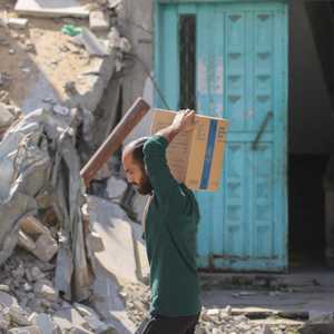 فلسطيني نازح يحمل صندوقا من المساعدات