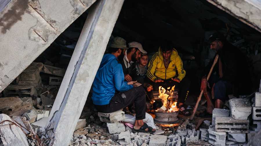 فلسطينيون يحتمون تحت ركام منزل بعد انهيار منزلهم جراء المطر