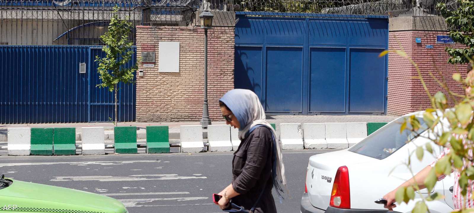 امرأة تسير أمام السفارة البريطانية في طهران