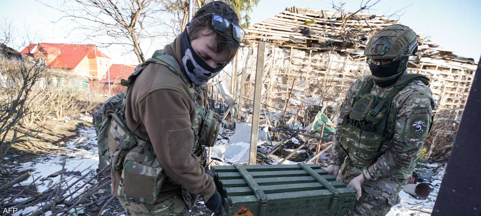 عنصران من القوات الروسية ينقلان ذخائر بإحدى جبهات القتال