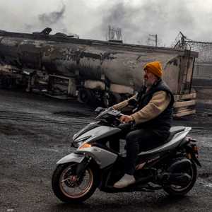 رجل خلفه آثار ضربة على مصفاة إيرانية