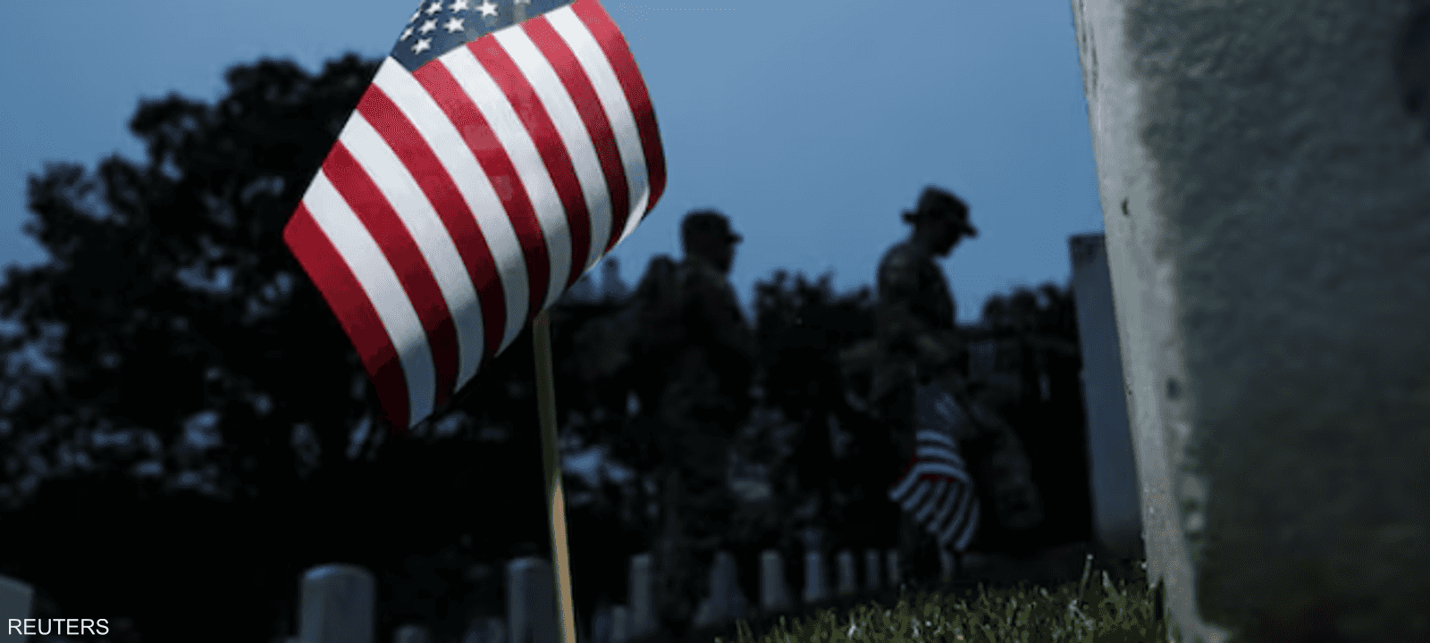 علم أميركا أمام شاهد قبر جندي بالجيش في مقبرة أرلينغتون