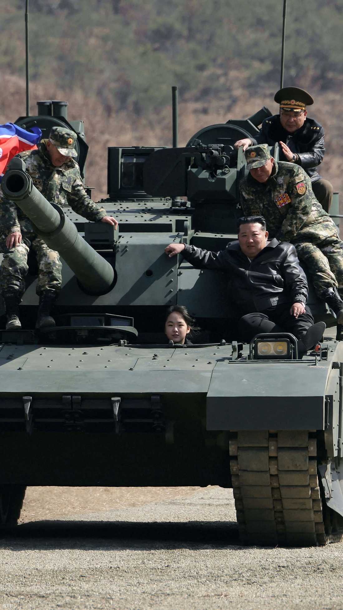 ابنة كيم تنظر من فتحة السائق فيما والدها فوق الدبابة