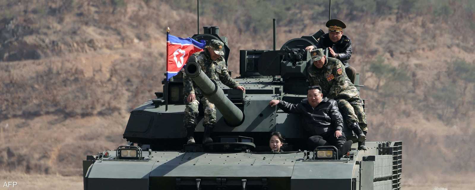 ابنة كيم تنظر من فتحة السائق فيما والدها فوق الدبابة