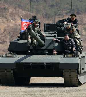 ابنة كيم تنظر من فتحة السائق فيما والدها فوق الدبابة