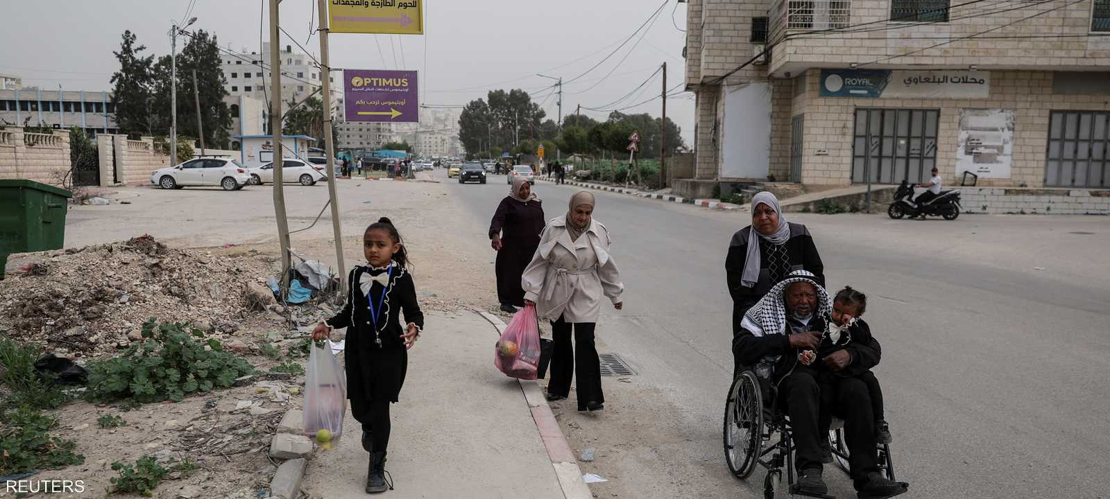 أفراد من عائلة غانم يسيرون في حي يستأجرون فيه غرفة في طولكرم