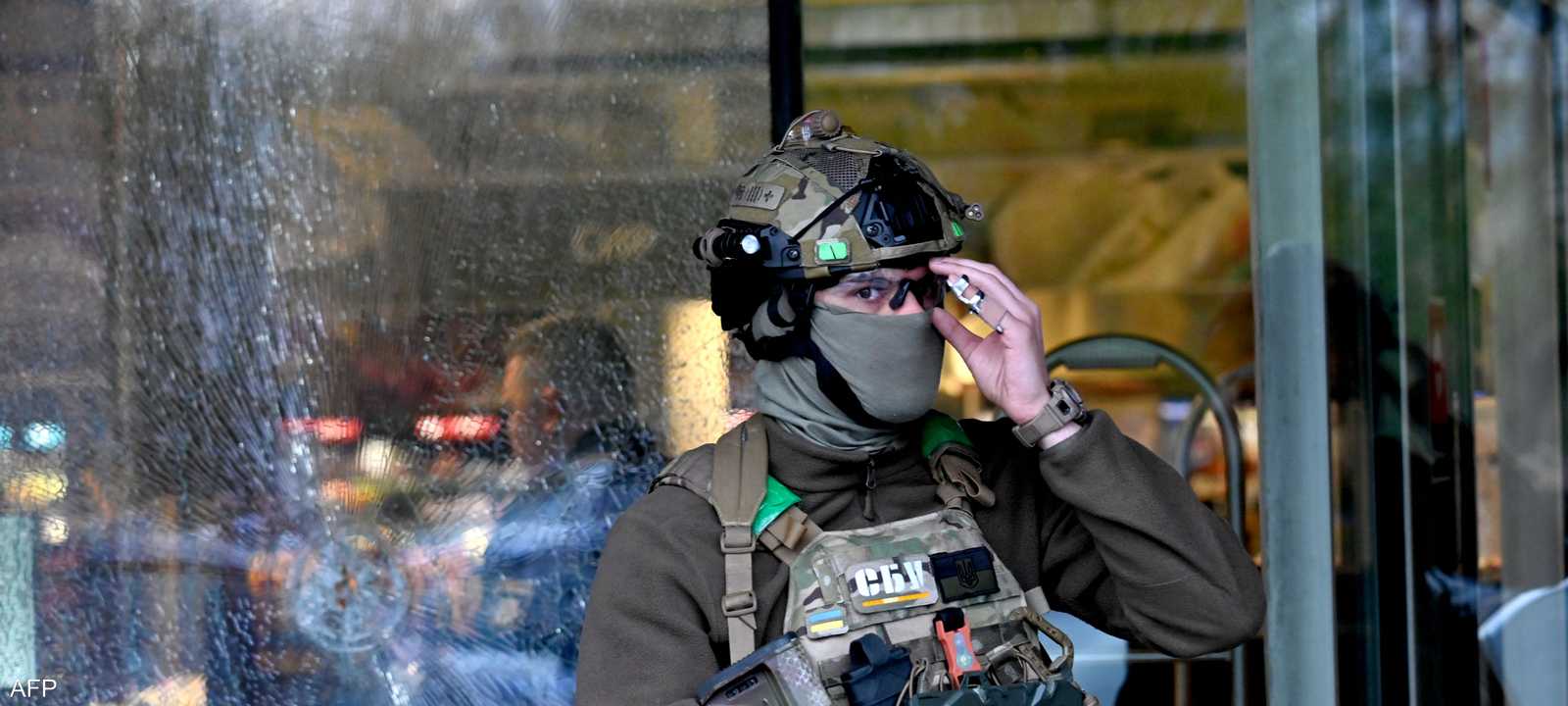 شرطي يقف أمام سوبر ماركت بعد حادث إطلاق نار في كييف
