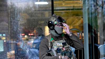 شرطي يقف أمام سوبر ماركت بعد حادث إطلاق نار في كييف