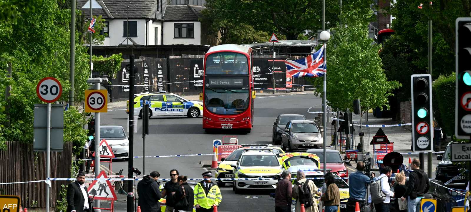 أفراد من وسائل الإعلام خلف طوق أمني بمكان حادث شمال لندن