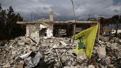 اية حزب الله اللبناني موضوعة أمام منزل دمرته غارة إسرائيلية