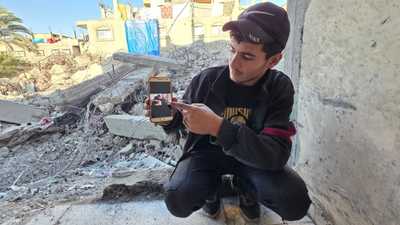على أنقاض منزله المدمر حيث فقد 55 شخصا من أفراد العائلة