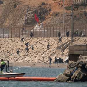 جنود مغاربة يقفون عند السياج الفاصل بين المغرب وجيب سبتة