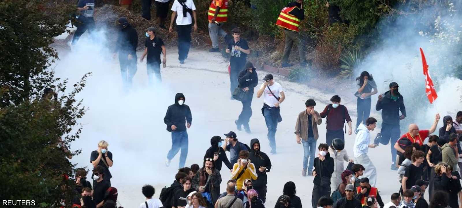 الطلاب المتظاهرون يسيرون وسط الغاز المسيل للدموع