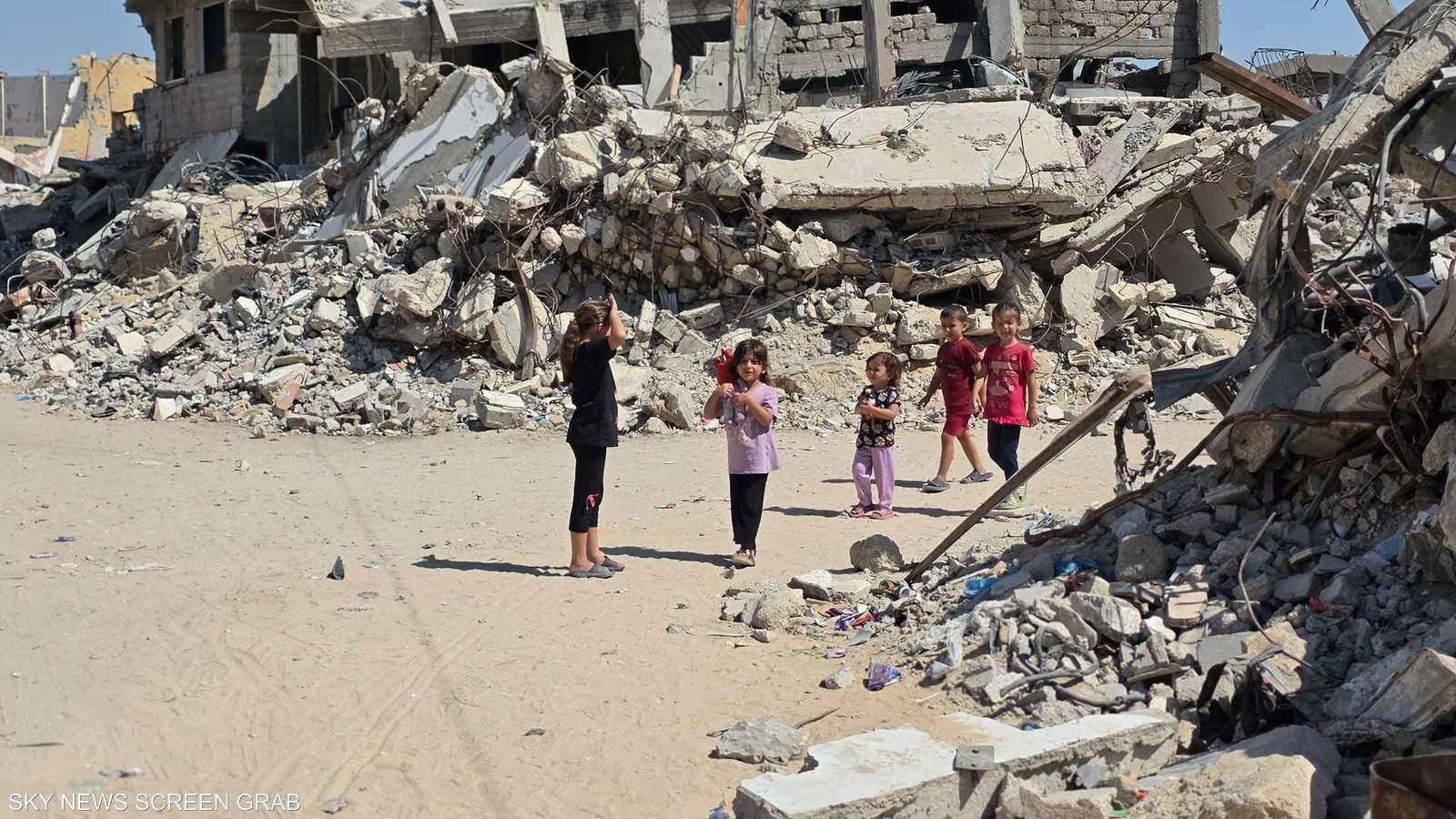 أطفال يمرون قرب مبان دمرتها الحرب